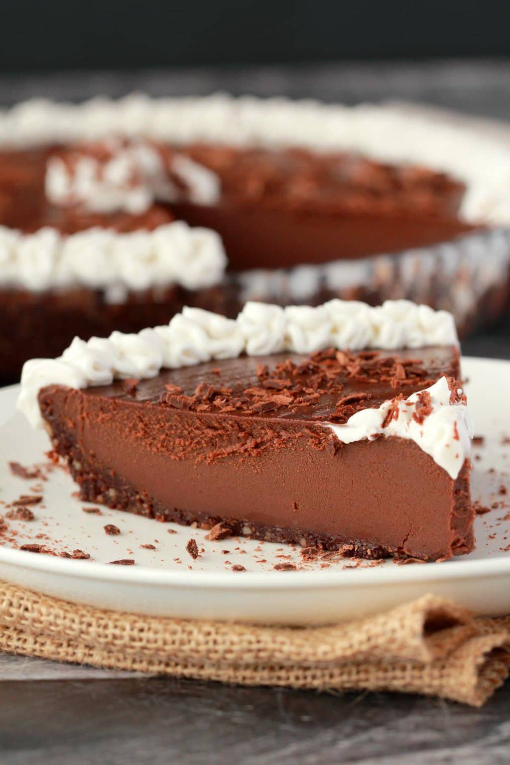 Tranche de tarte au chocolat végétalien sur une plaque blanche. 