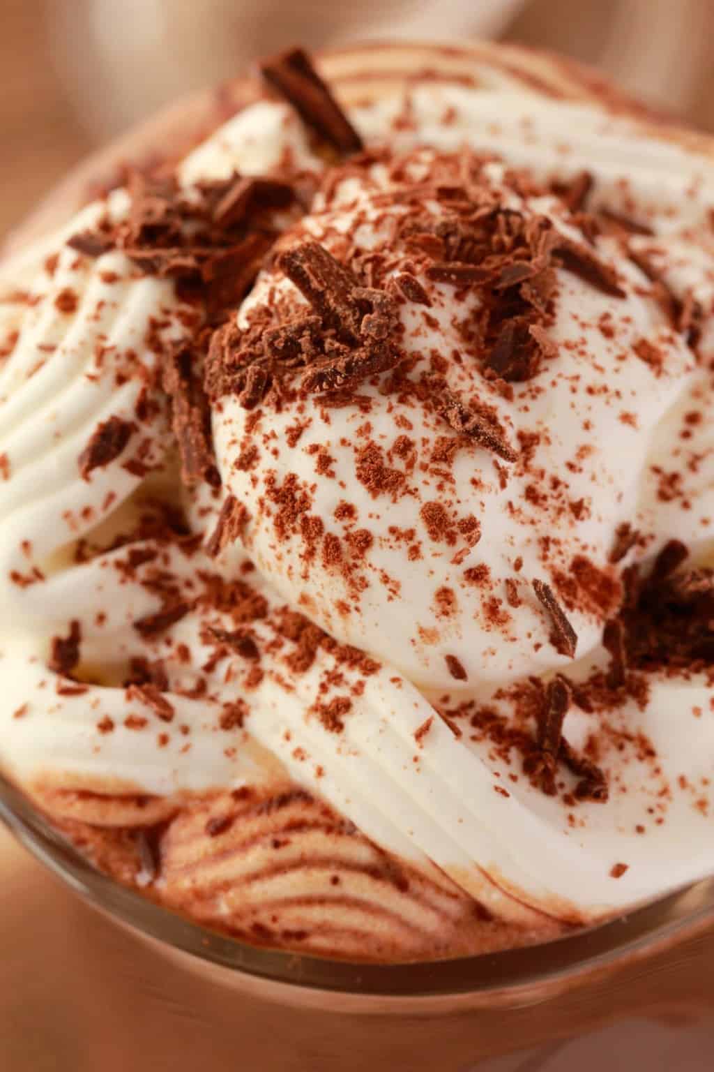 Chocolat chaud végétalien garni de crème fouettée et de copeaux de chocolat.