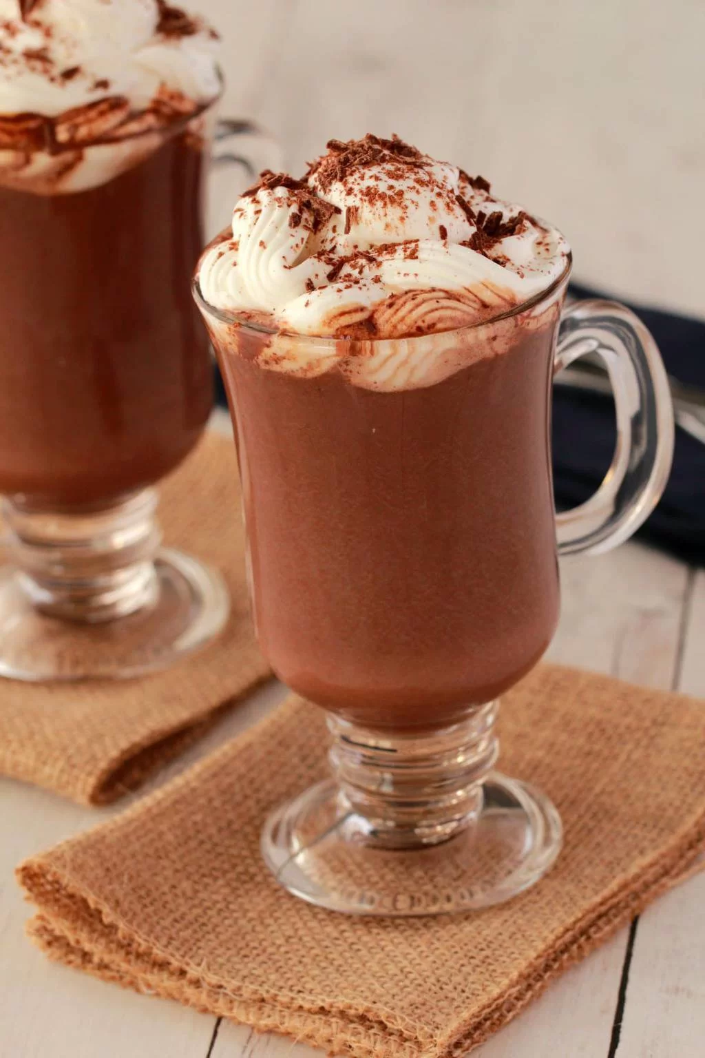 Chocolat chaud végétalien dans des tasses en verre garni de crème fouettée végétalienne. 