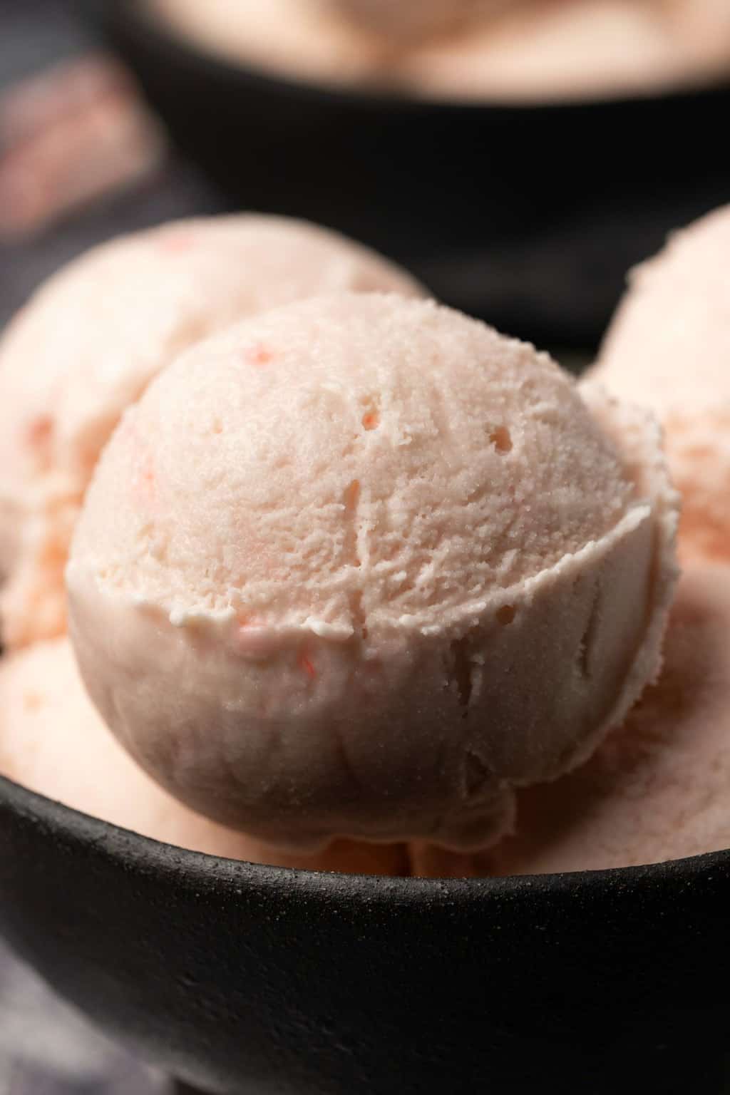 Boules de crème glacée végétalienne à la menthe poivrée dans un bol noir. 