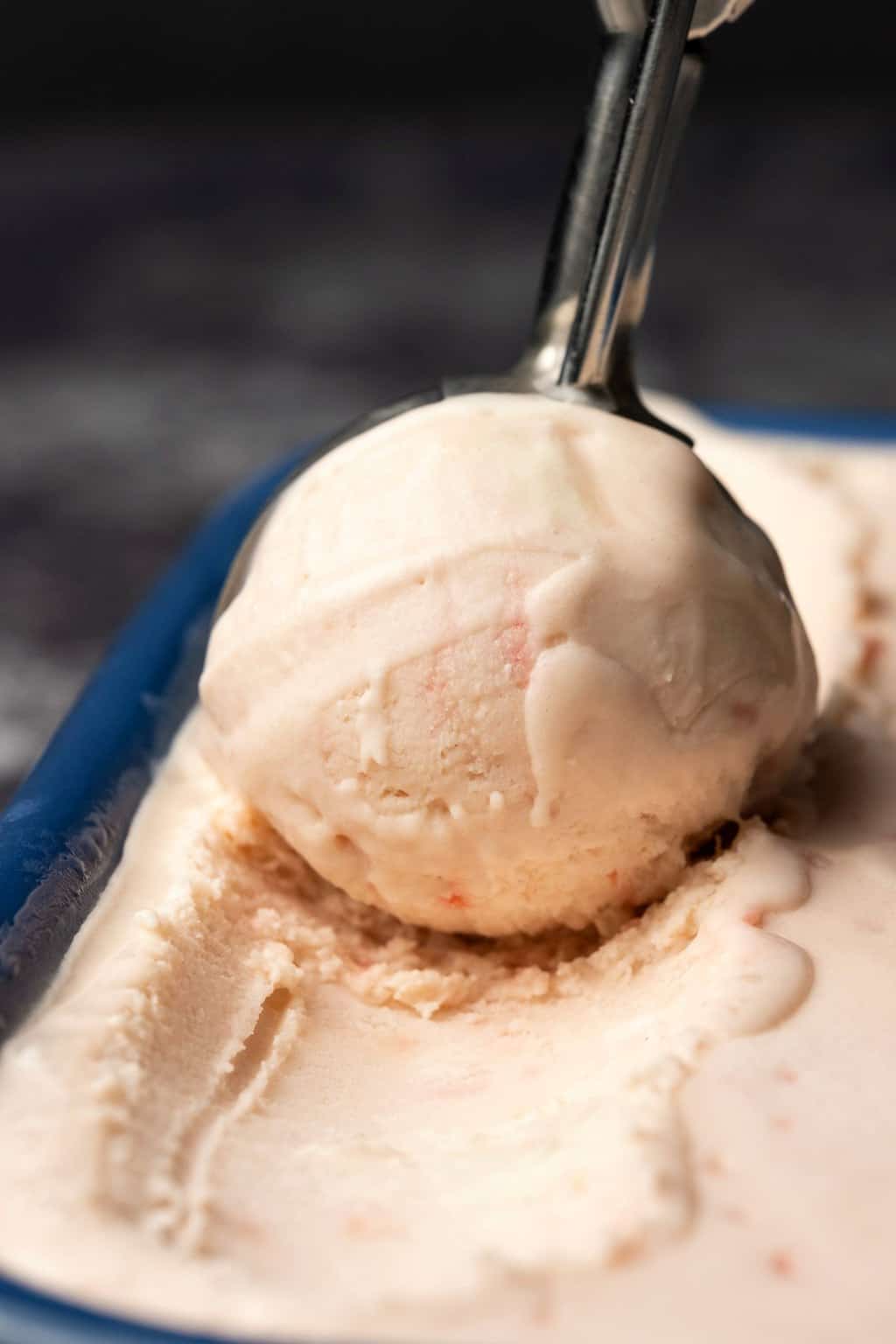 Glace végétalienne à la menthe poivrée dans un plat en céramique bleu avec une cuillère à crème glacée. 