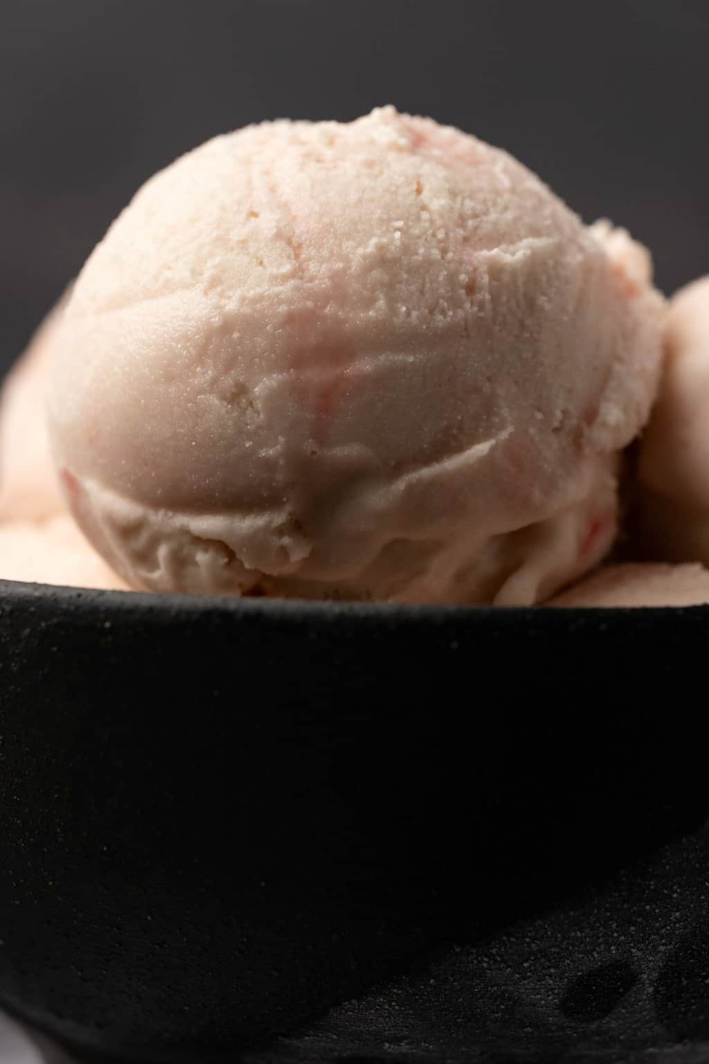 Boules de crème glacée végétalienne à la menthe poivrée dans un bol noir. 