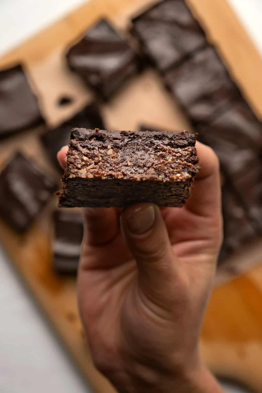 Tenant un brownie végétalien cru.