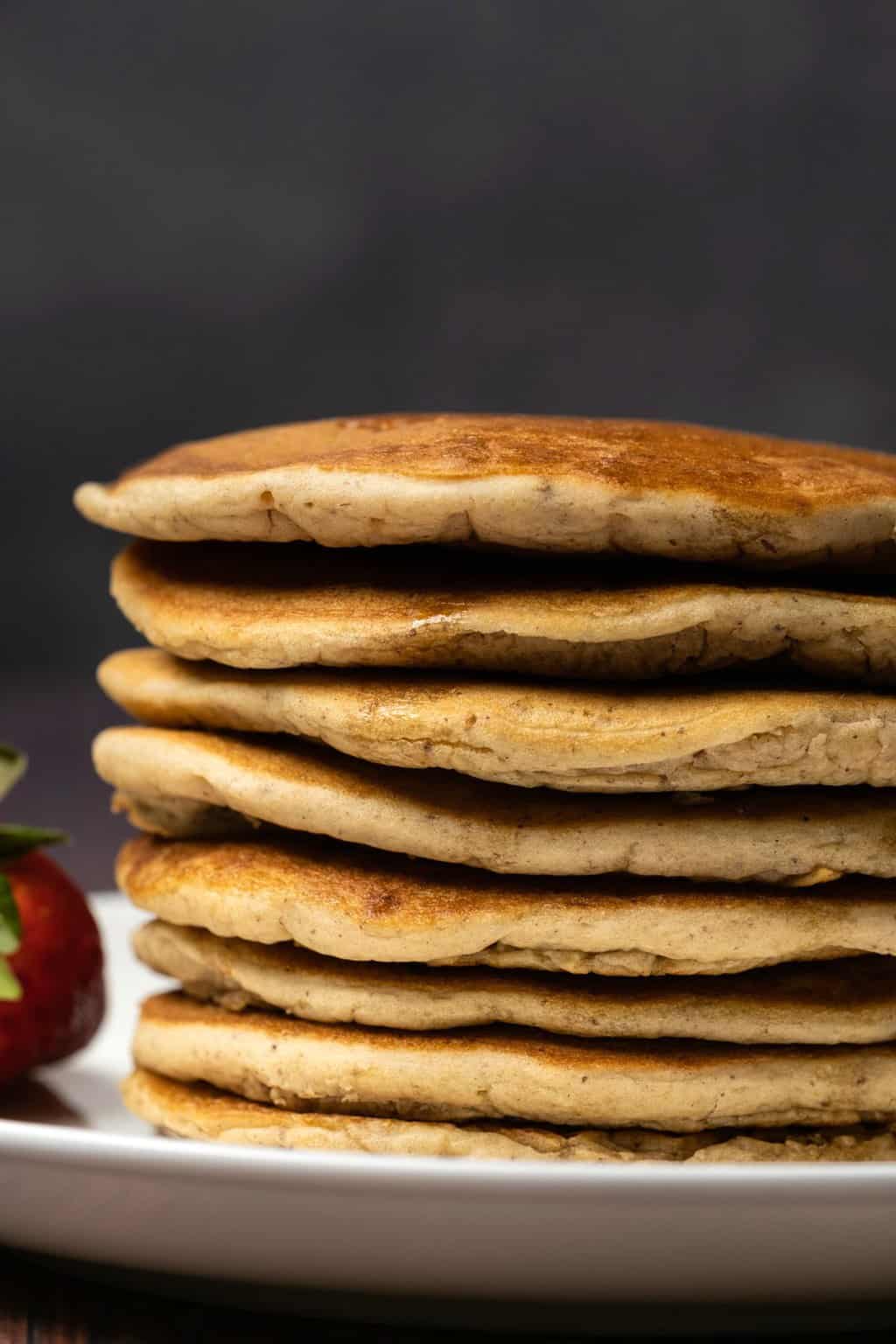 Crêpes protéinées végétaliennes dans une pile sur une plaque blanche.