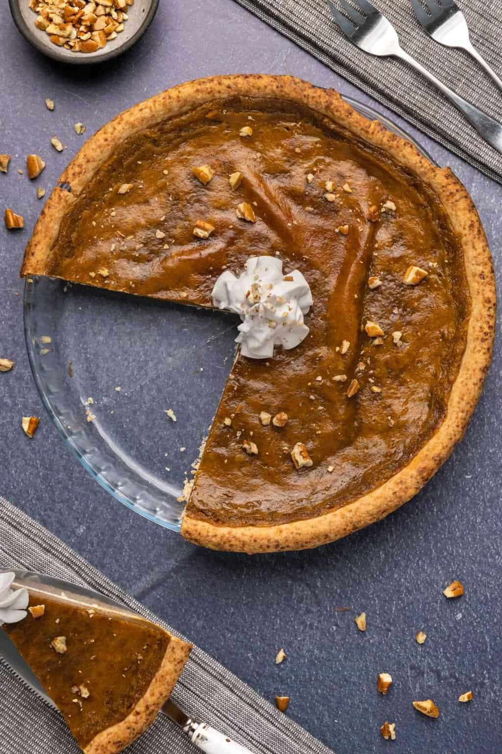 Tarte aux patates douces végétalienne dans un plat en verre avec quelques tranches retirées.