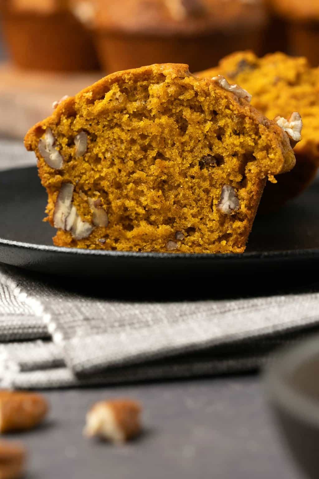 Muffin à la citrouille coupé en deux sur une plaque noire. 