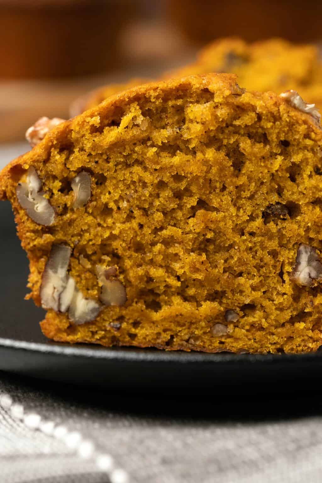 Muffin citrouille végétalien coupé en deux sur une assiette. 