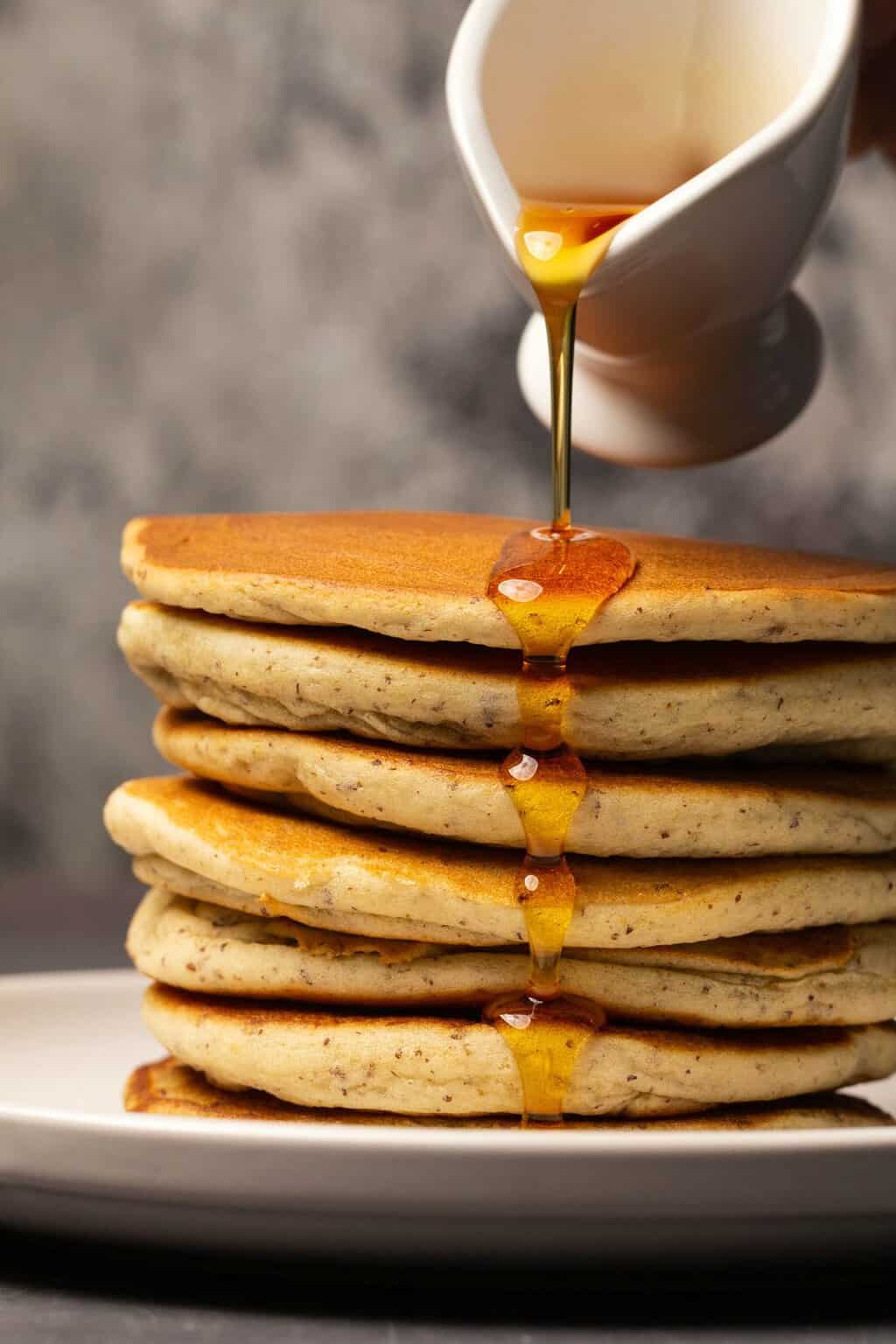 Verser le sirop sur une pile de crêpes végétaliennes sans gluten.