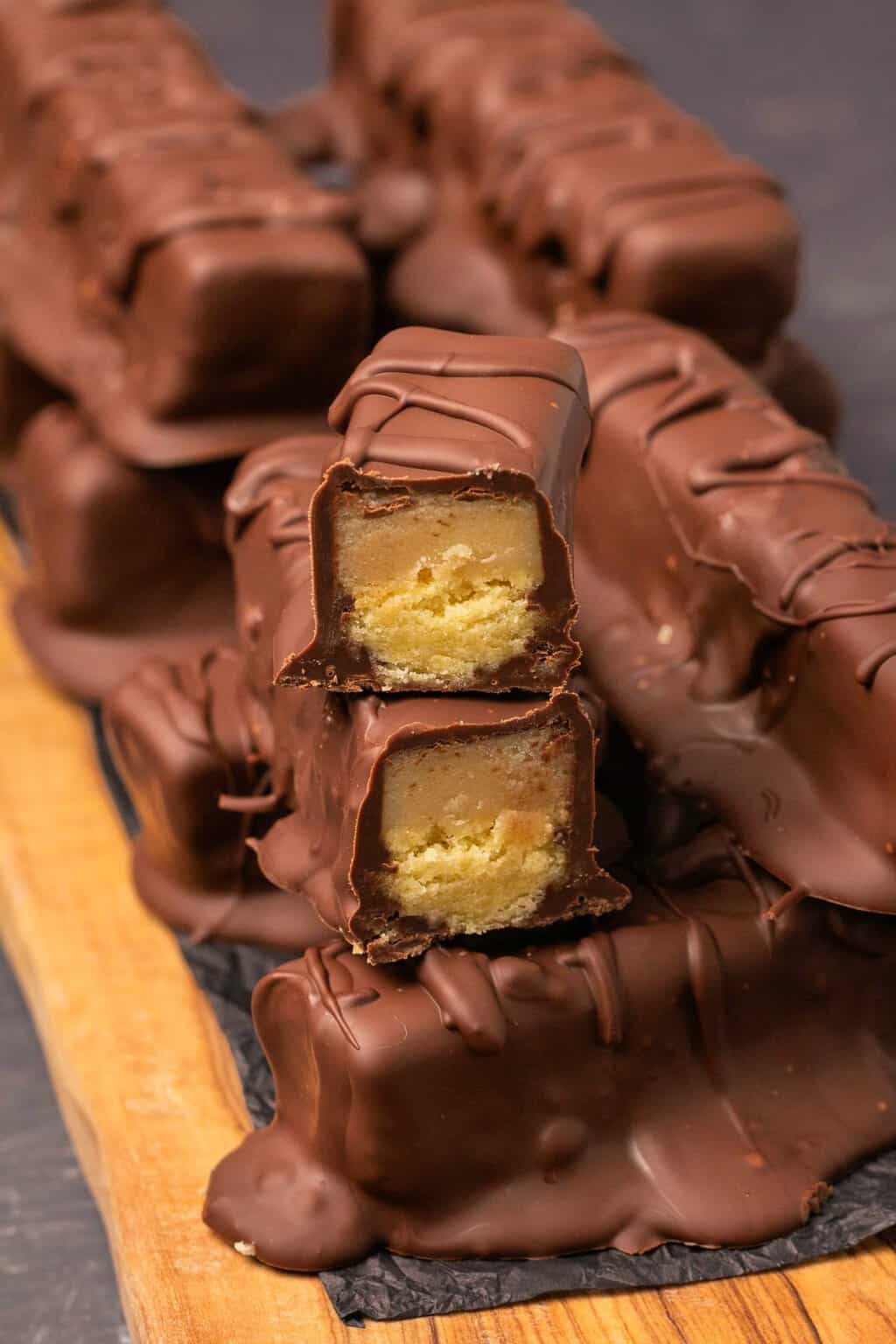 Twix bars végétaliens empilés sur une planche de bois.