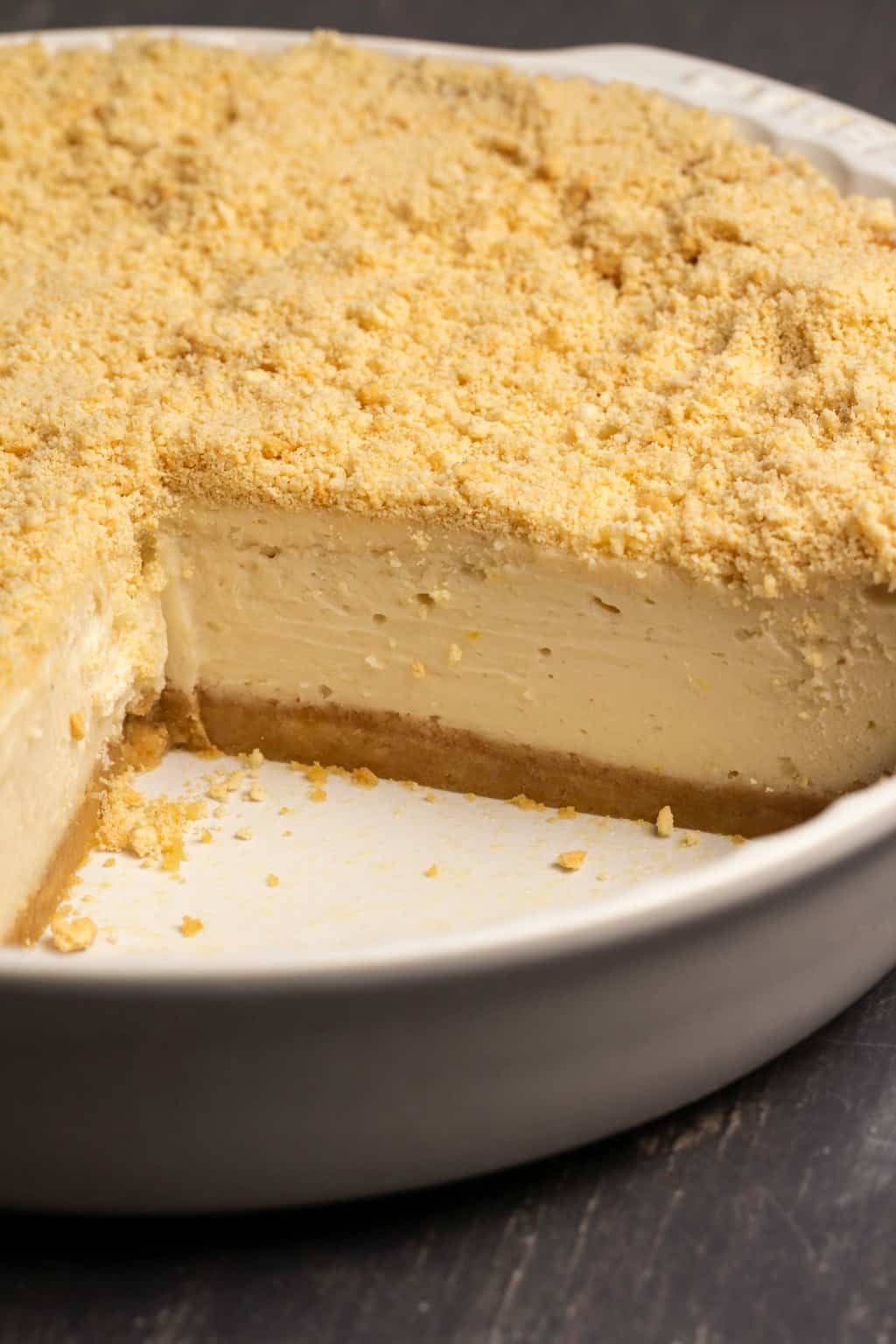 Gâteau au fromage sans produits laitiers dans un plat à tarte blanc.