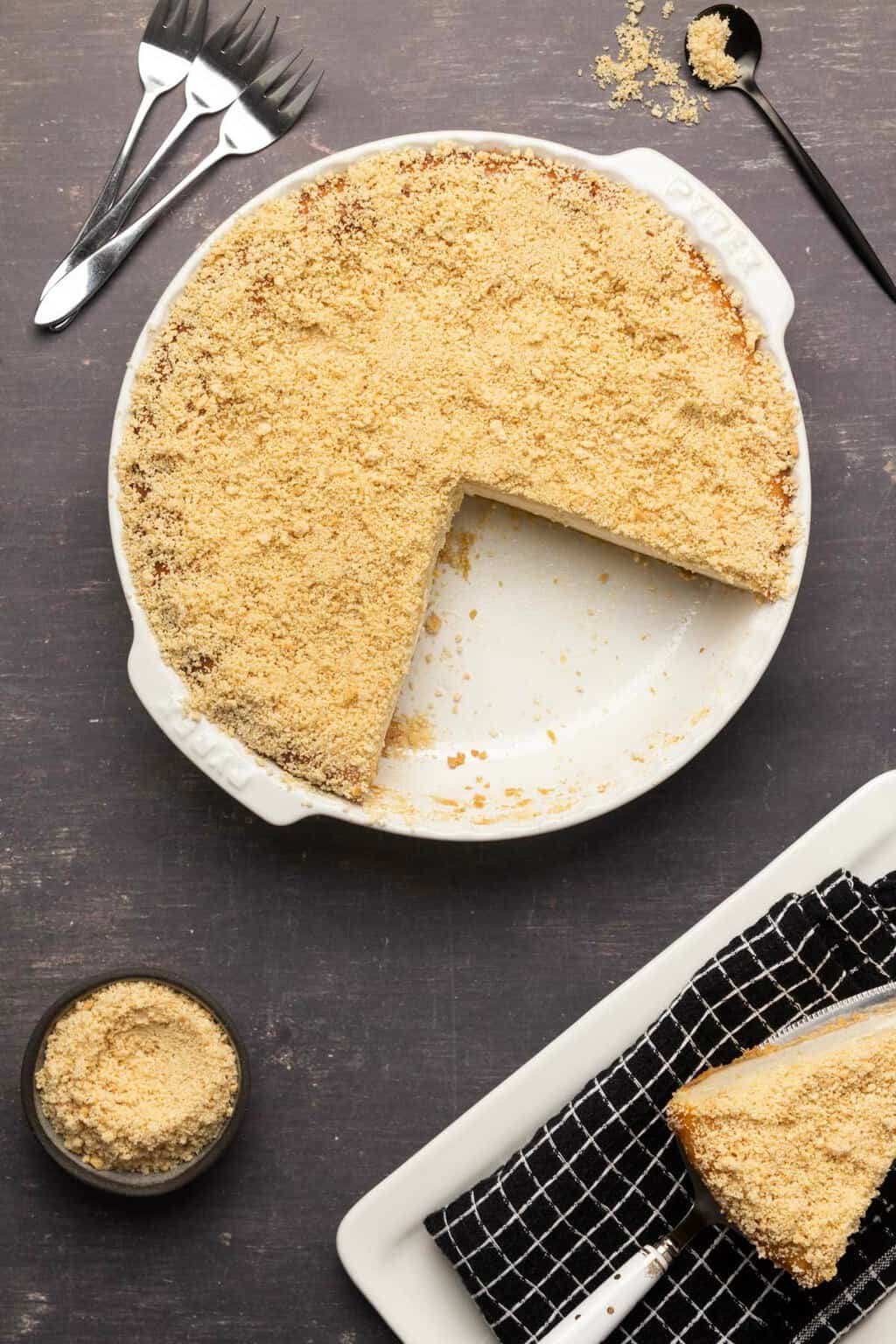 Gâteau au fromage sans produits laitiers garni de biscuits oreo écrasés dans un plat à tarte blanc.