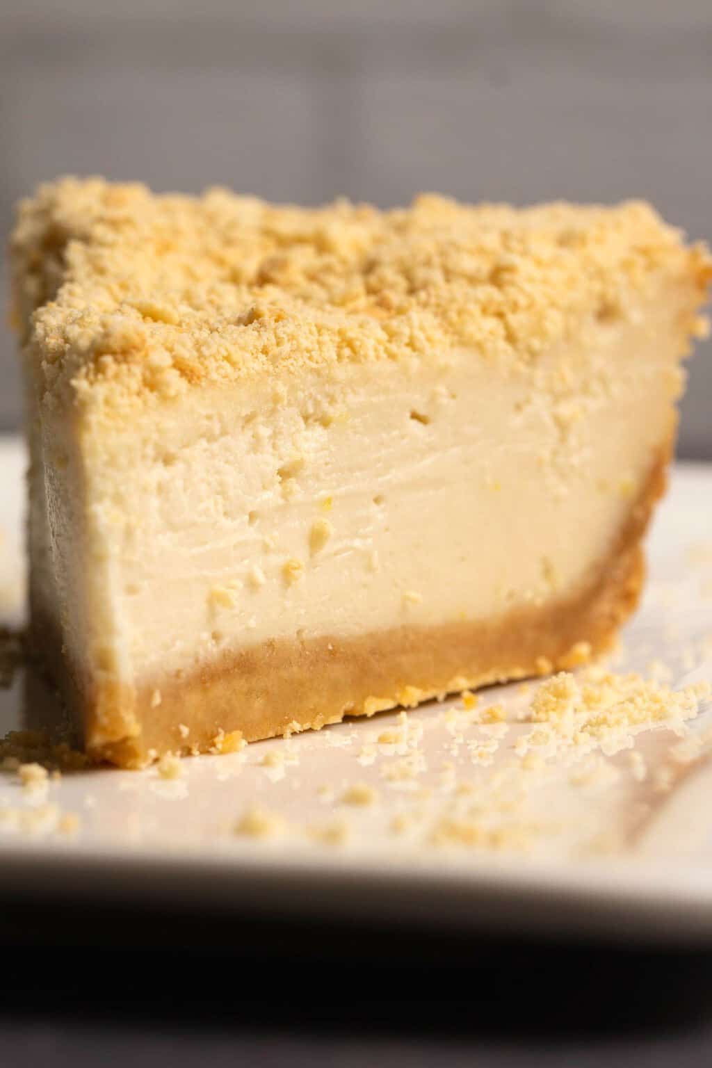 Tranche de gâteau au fromage végétalien sur une plaque blanche.