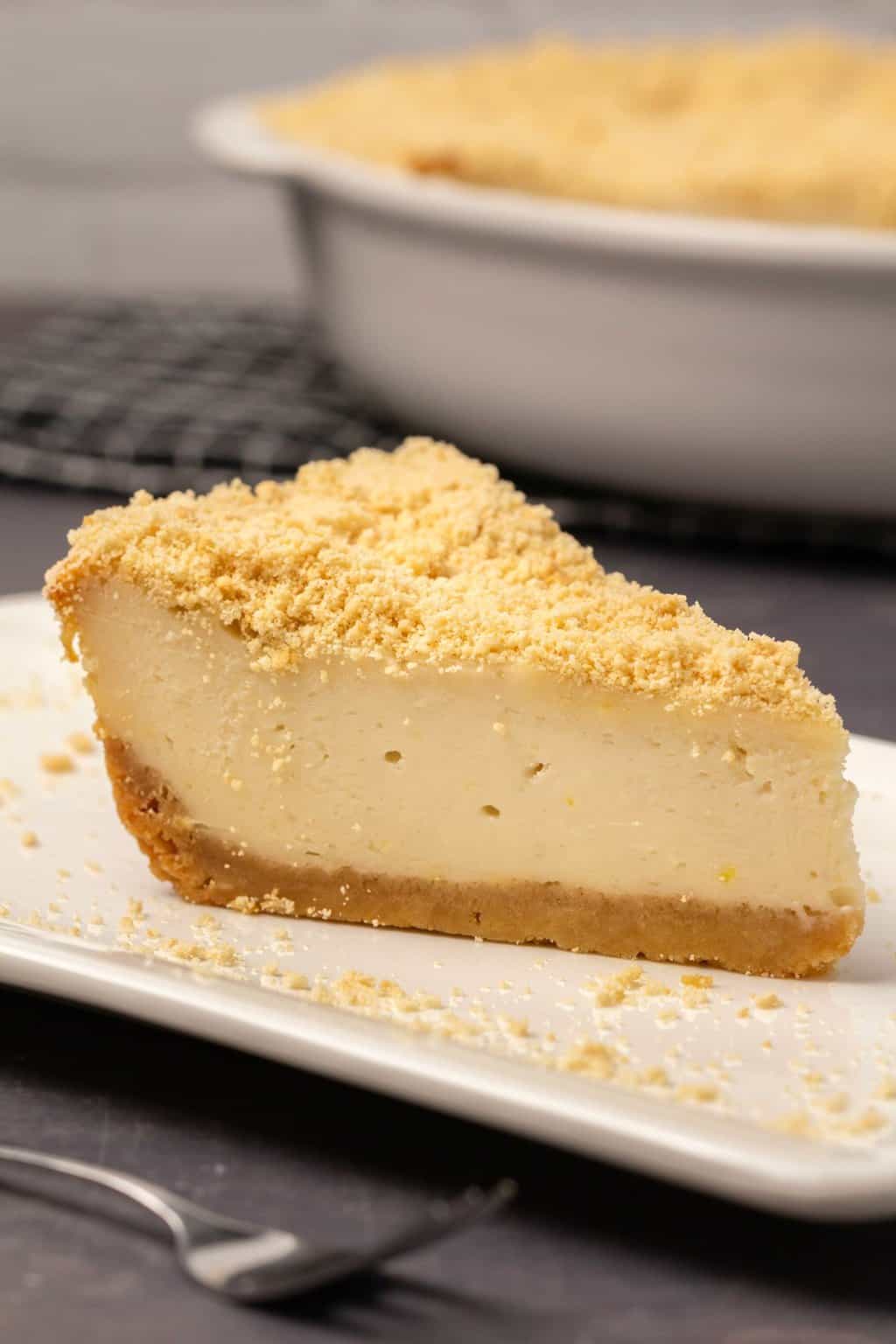 Tranche de gâteau au fromage sans produits laitiers sur une plaque blanche.