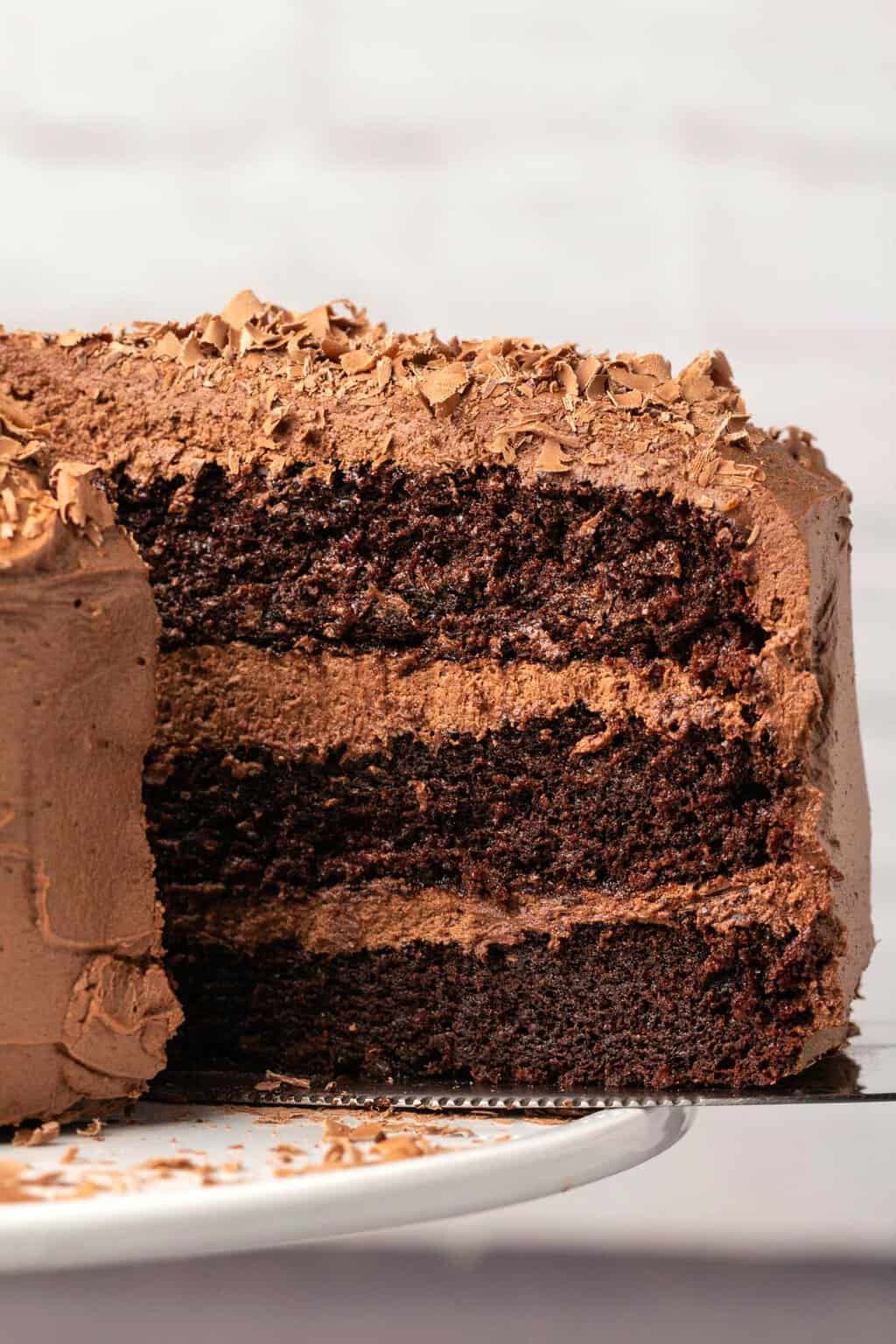 Tranche de gâteau au chocolat sans produits laitiers sur un gâteau.