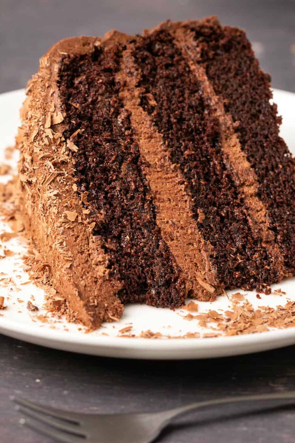 Tranche de gâteau au chocolat sans produits laitiers sur une plaque blanche.