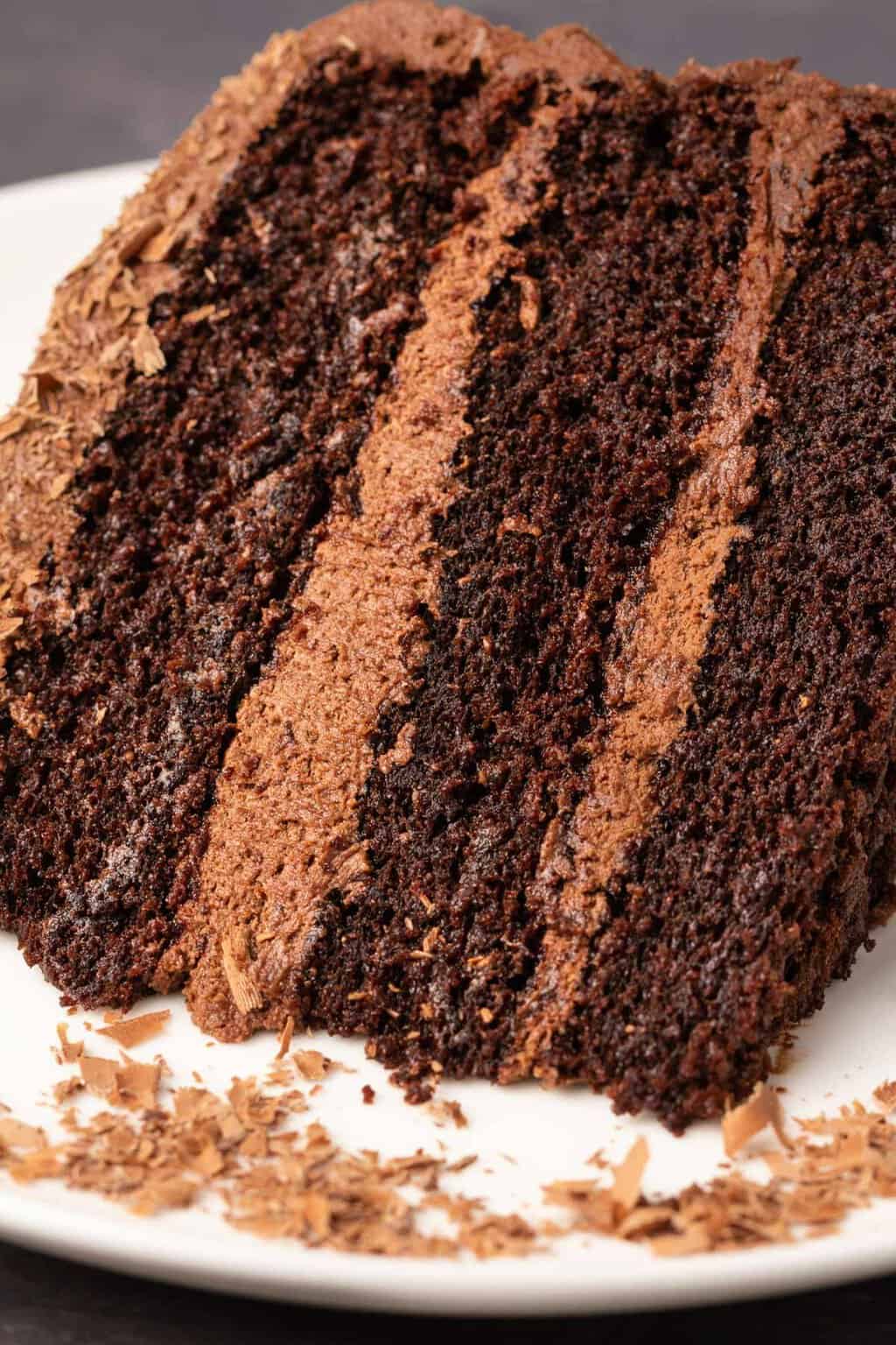 Tranche de gâteau au chocolat sans produits laitiers sur une plaque blanche.