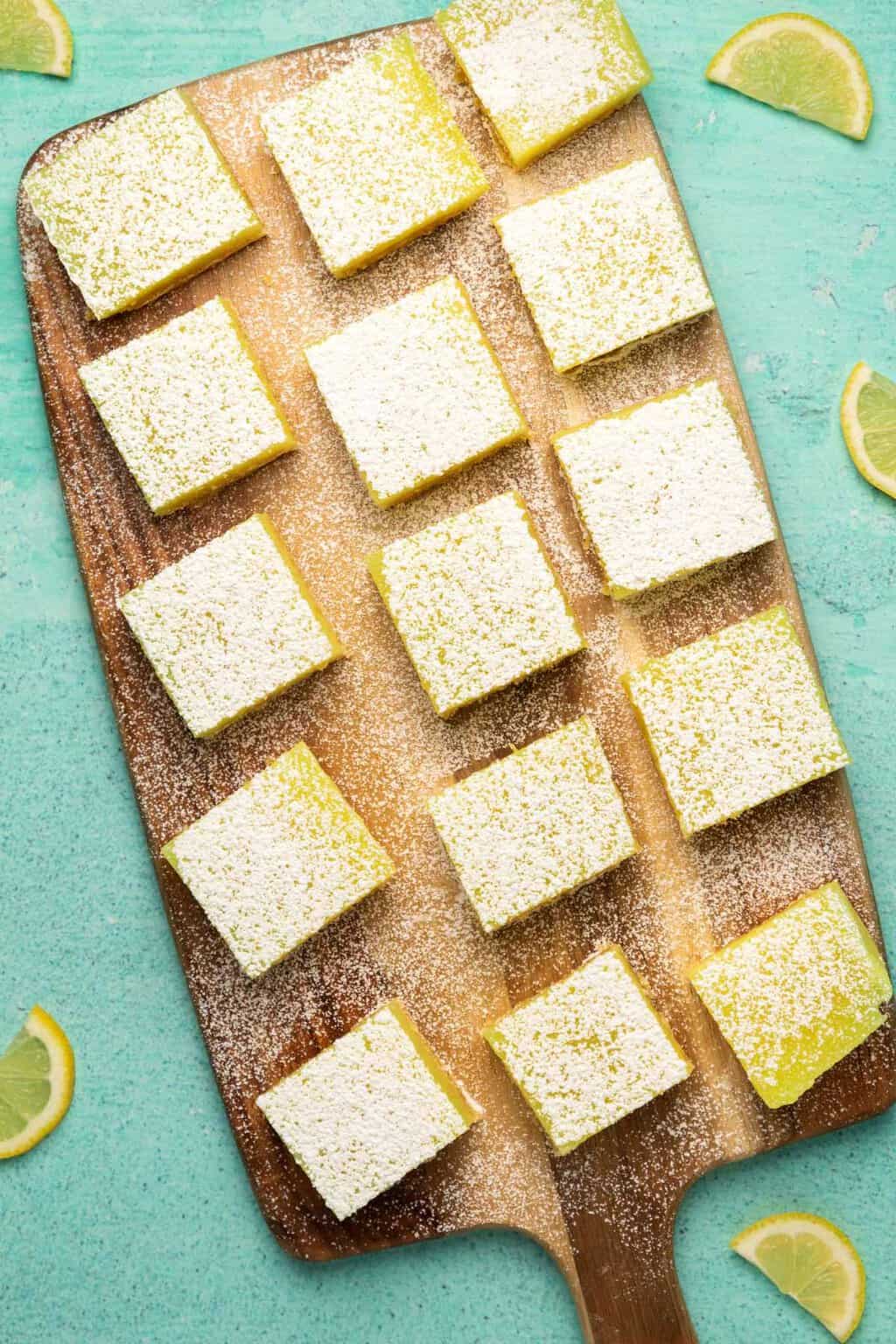 Barres de citron végétaliennes coupées en carrés sur une planche de bois.