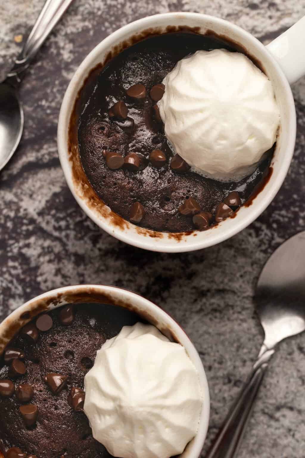Gâteau mug végétalien garni de crème végétalienne et de pépites de chocolat. 