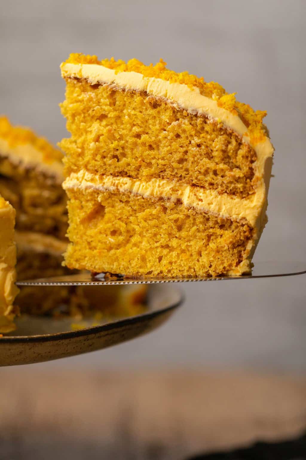 Tranche de gâteau orange végétalien sur un lifter à gâteau. 