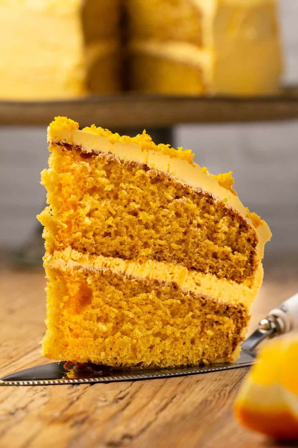 Tranche de gâteau orange végétalien sur un lifter à gâteau. 