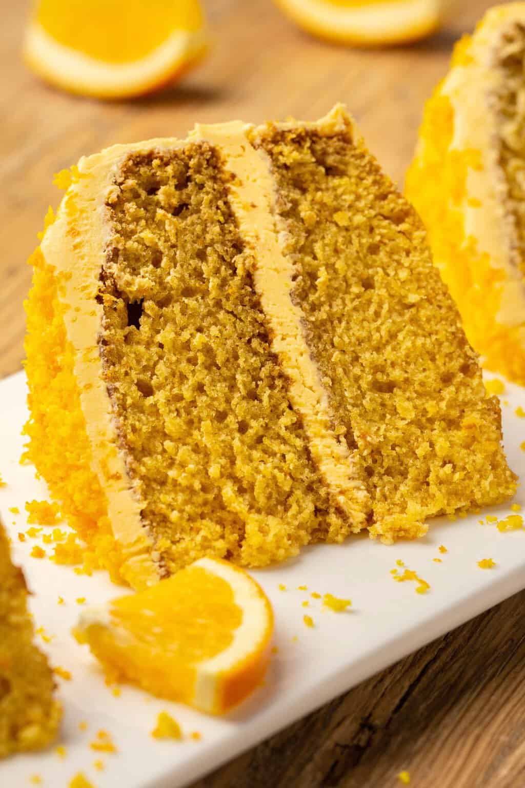 Tranche de gâteau orange végétalien sur une plaque blanche. 
