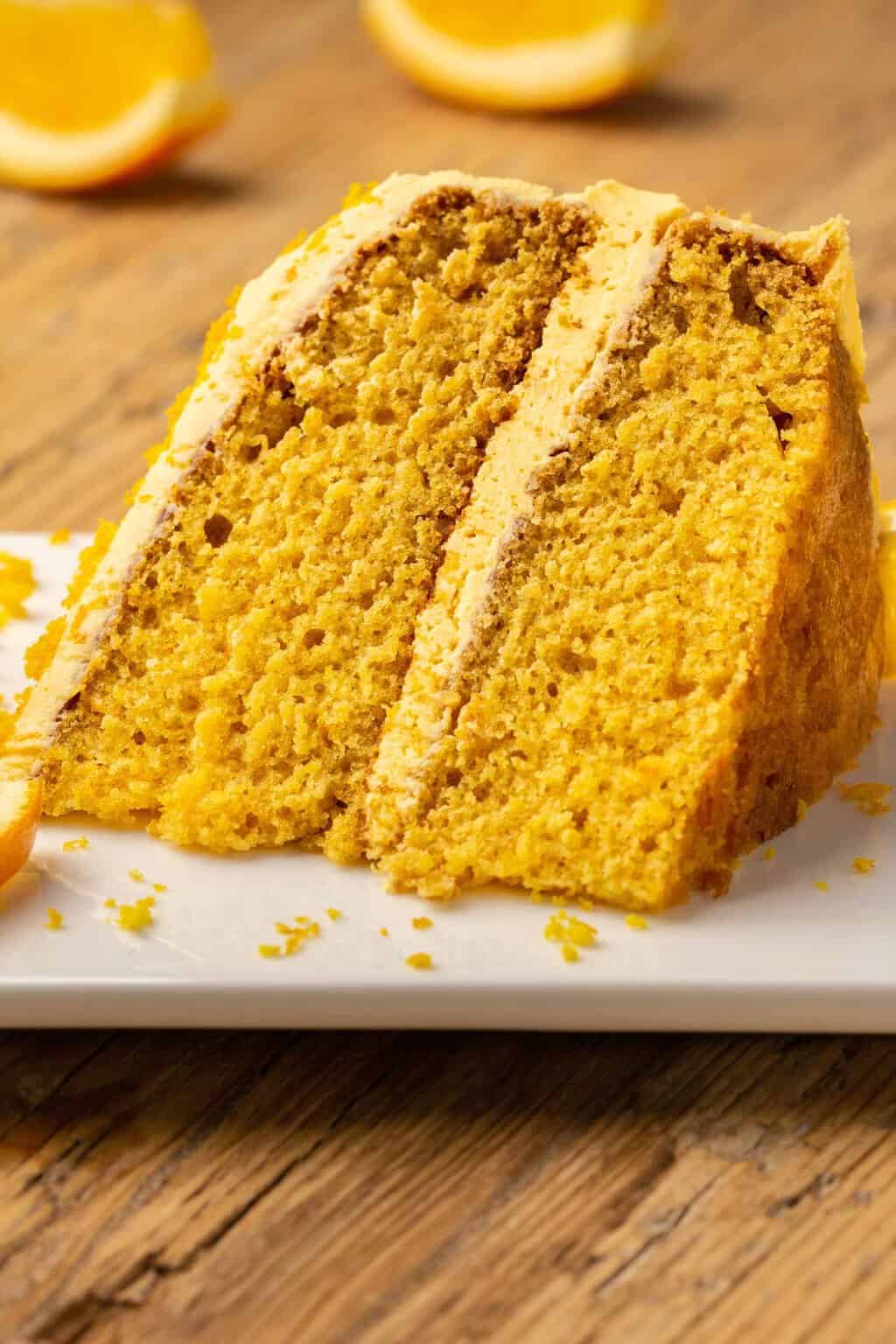 Tranche de gâteau orange végétalien sur une plaque blanche. 