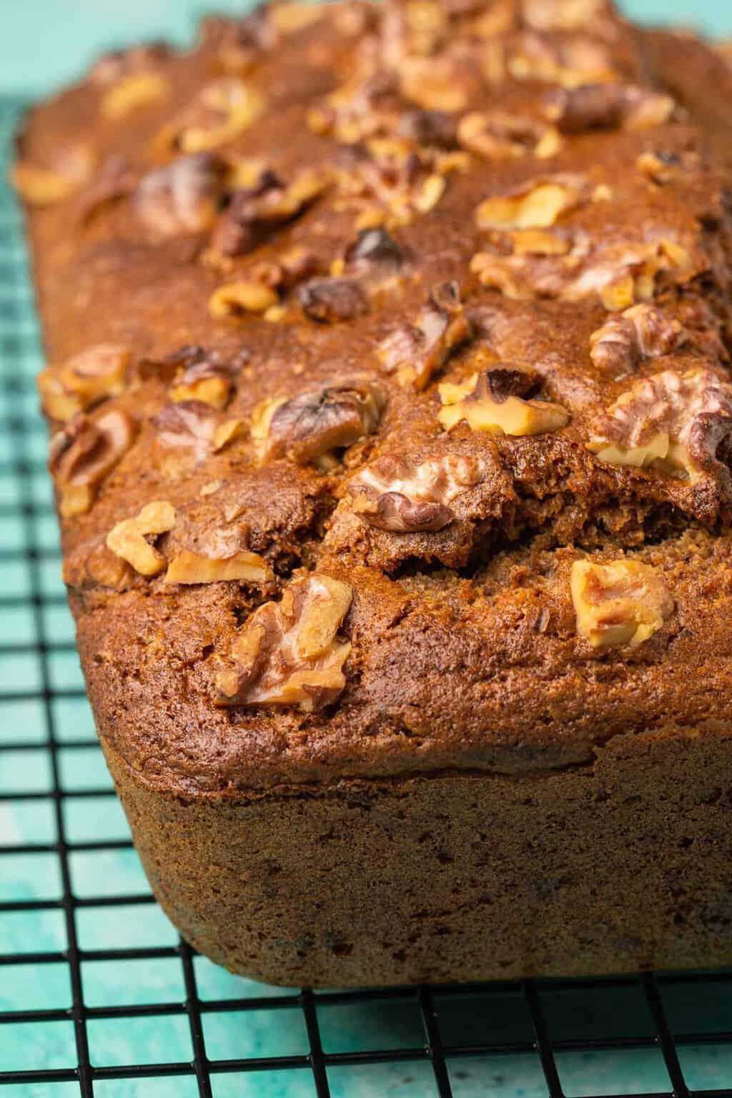 Une miche de pain aux bananes végétalien sans gluten sur une grille de refroidissement.