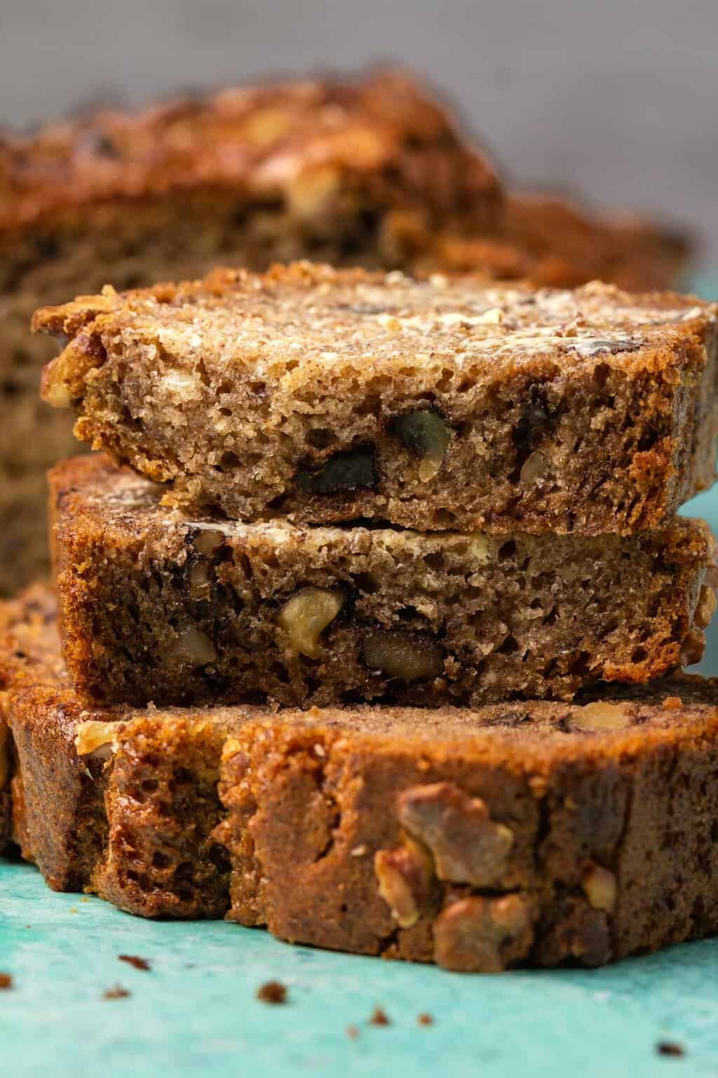 Tranches de pain aux bananes sans gluten végétalien beurré dans une pile.