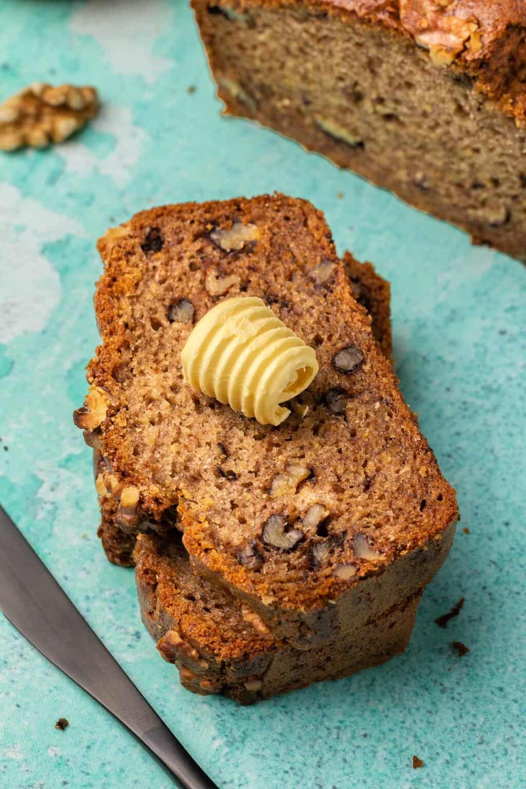 Tranches de pain aux bananes sans gluten végétalien avec une noix de beurre sur le dessus.