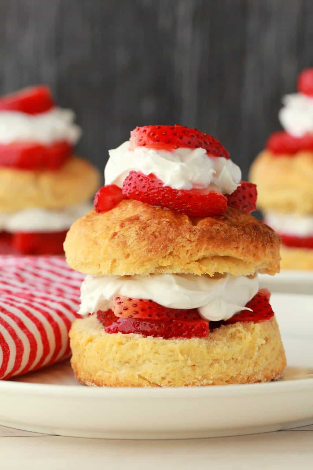 Sablé aux fraises végétalien sur une plaque blanche avec une serviette rouge et blanche. 