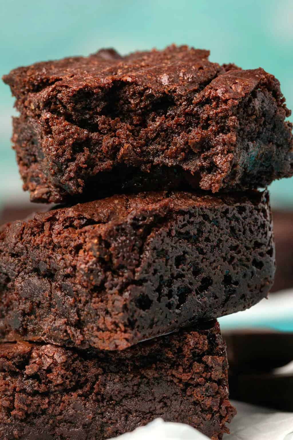 Brownies végétaliens sans gluten dans une pile avec une bouchée de celui du haut.