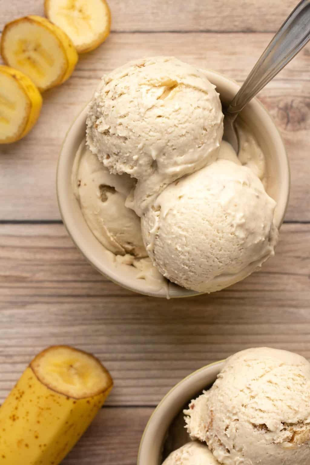 Boules de glace à la banane végétalienne dans un bol avec une cuillère.