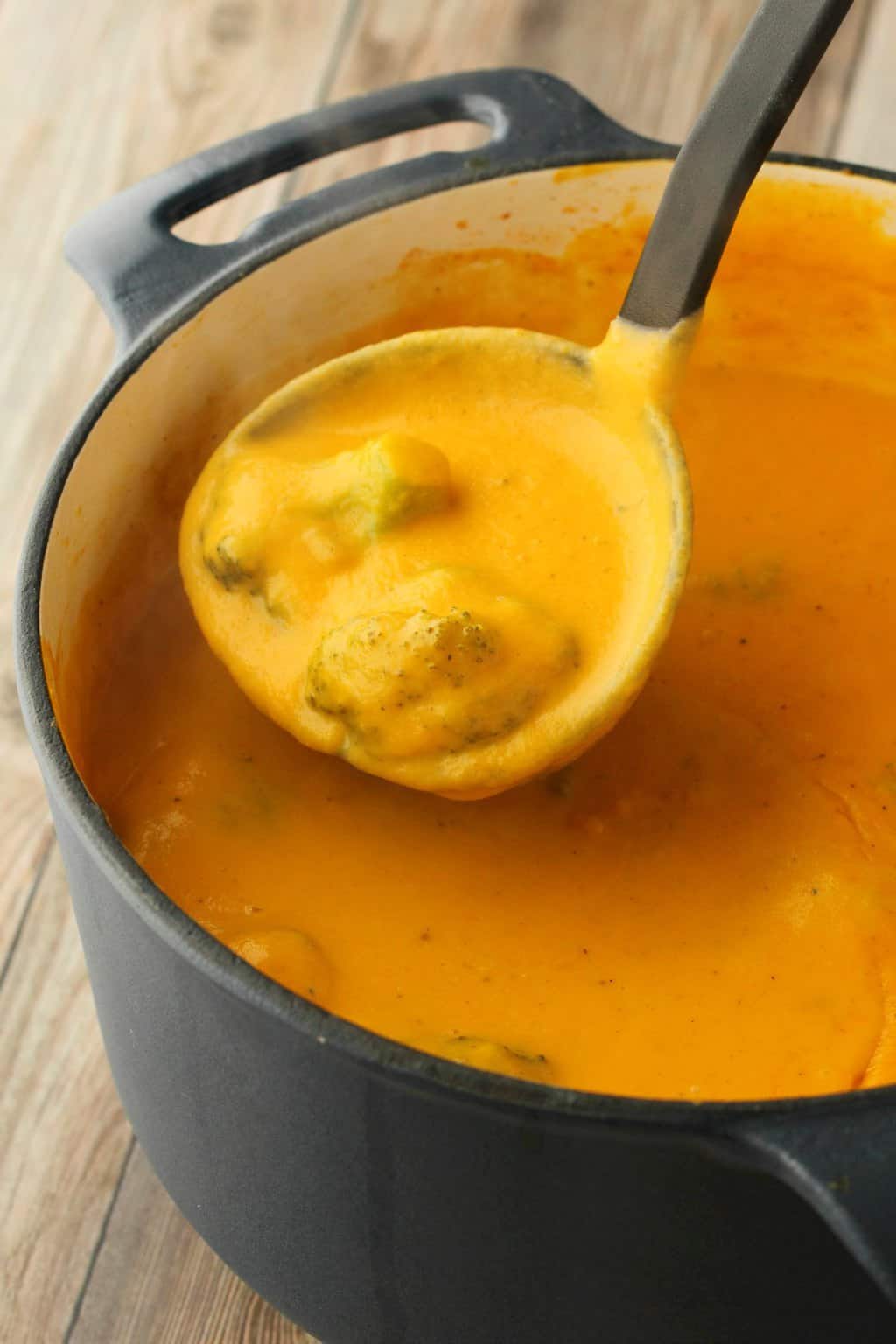 Soupe de fromage au brocoli végétalien dans une casserole avec une louche à soupe. 
