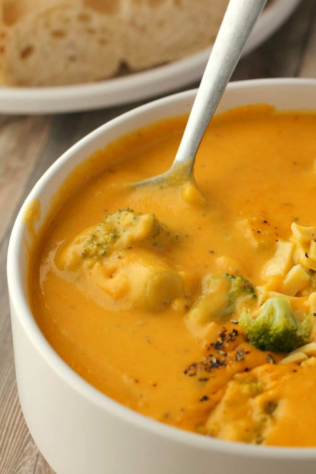 Soupe de fromage au brocoli végétalien dans un bol blanc avec une cuillère. 