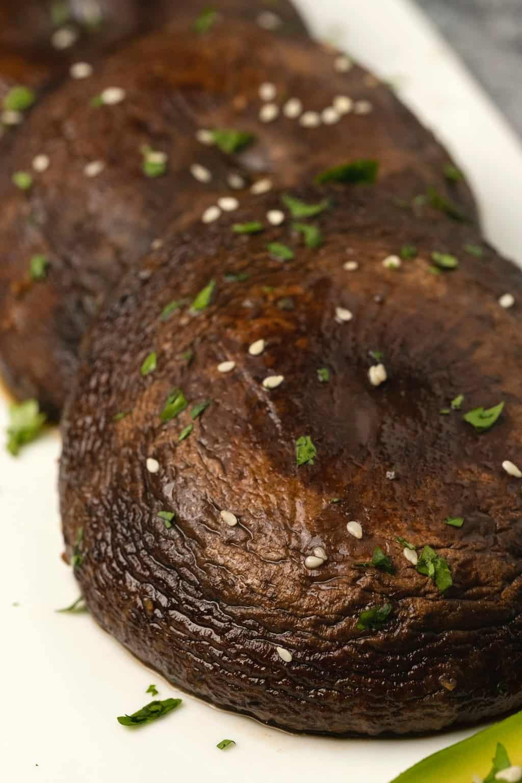 Champignons portobello au four sur une plaque blanche. 