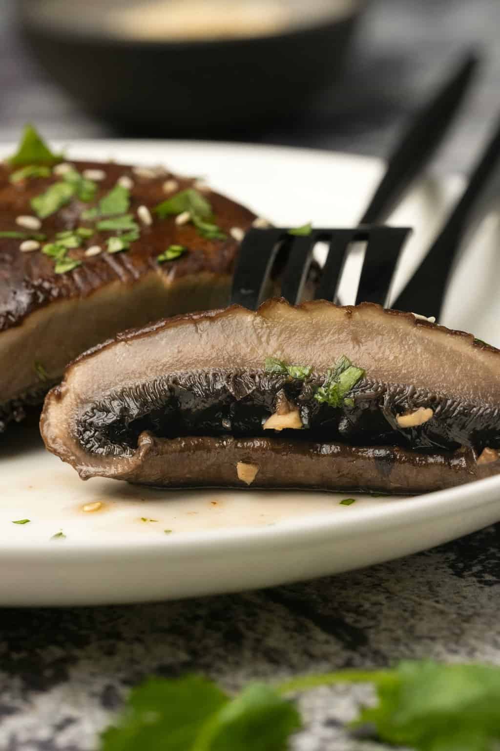 Champignons portobello en tranches sur une assiette avec une fourchette. 