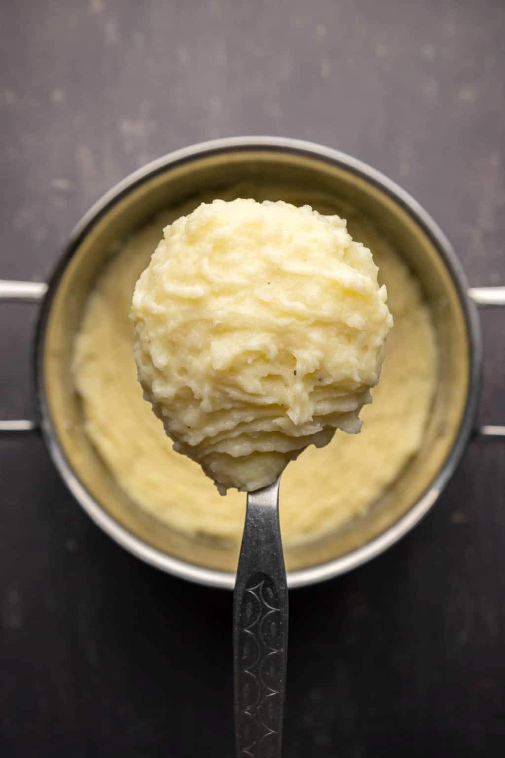 Purée de pommes de terre dans une casserole avec une cuillère de service. 