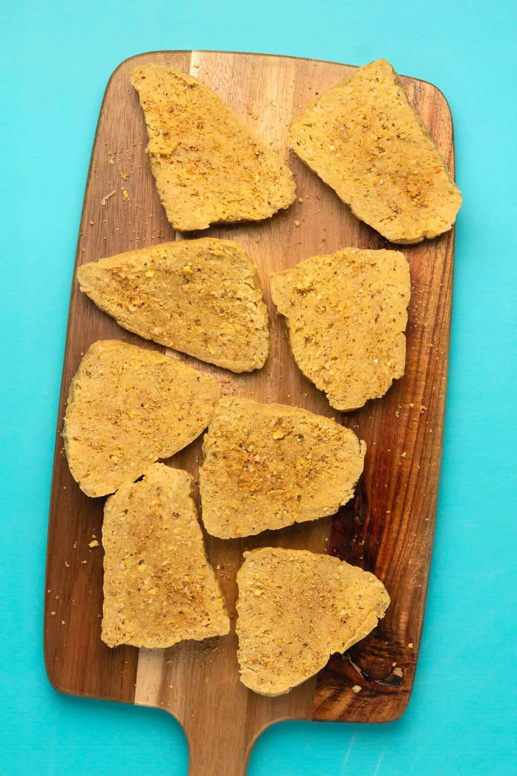 Filets de poulet végétalien sur une planche à découper en bois.