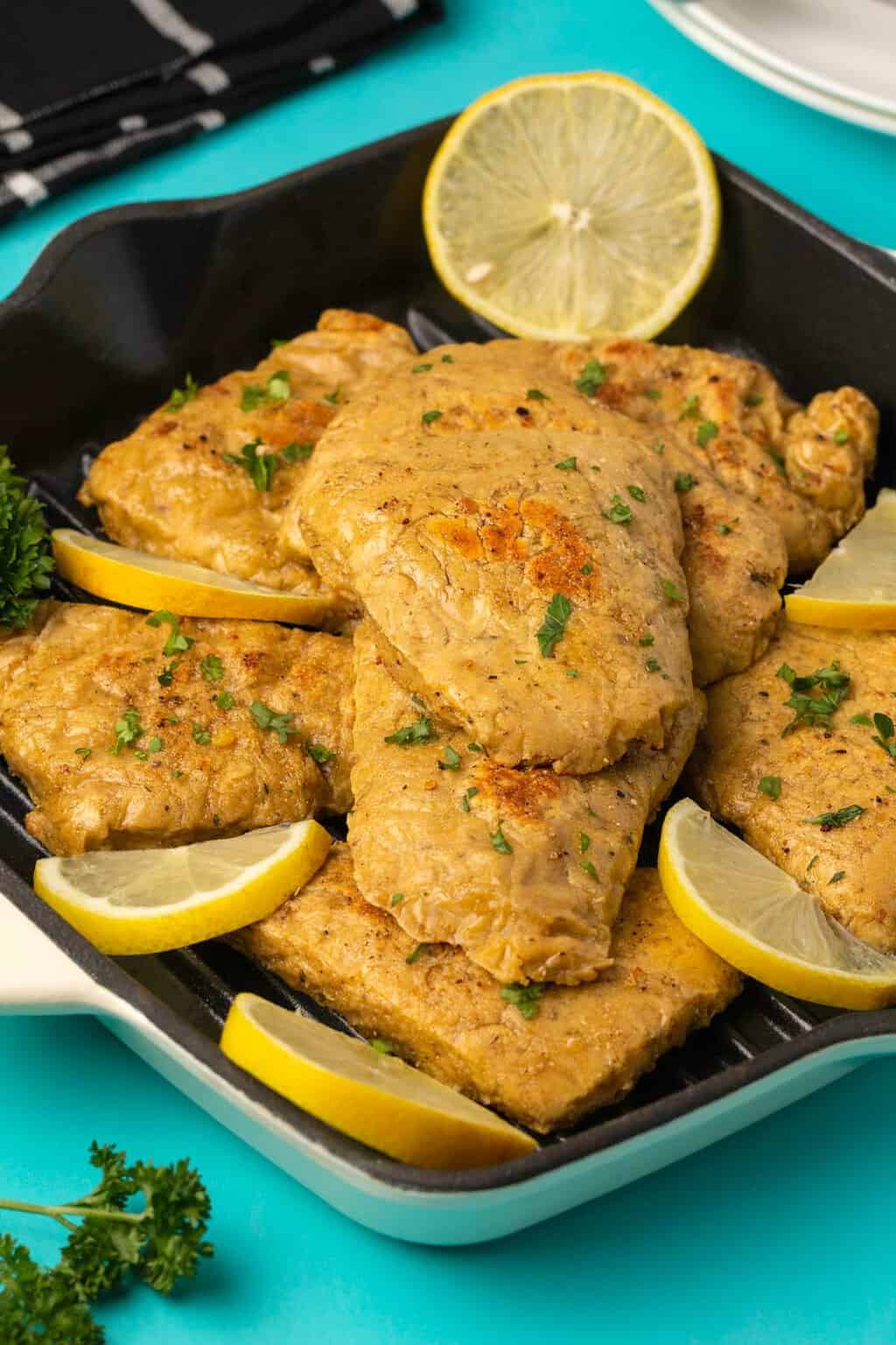 Filets de poulet végétaliens avec persil haché et tranches de citron.