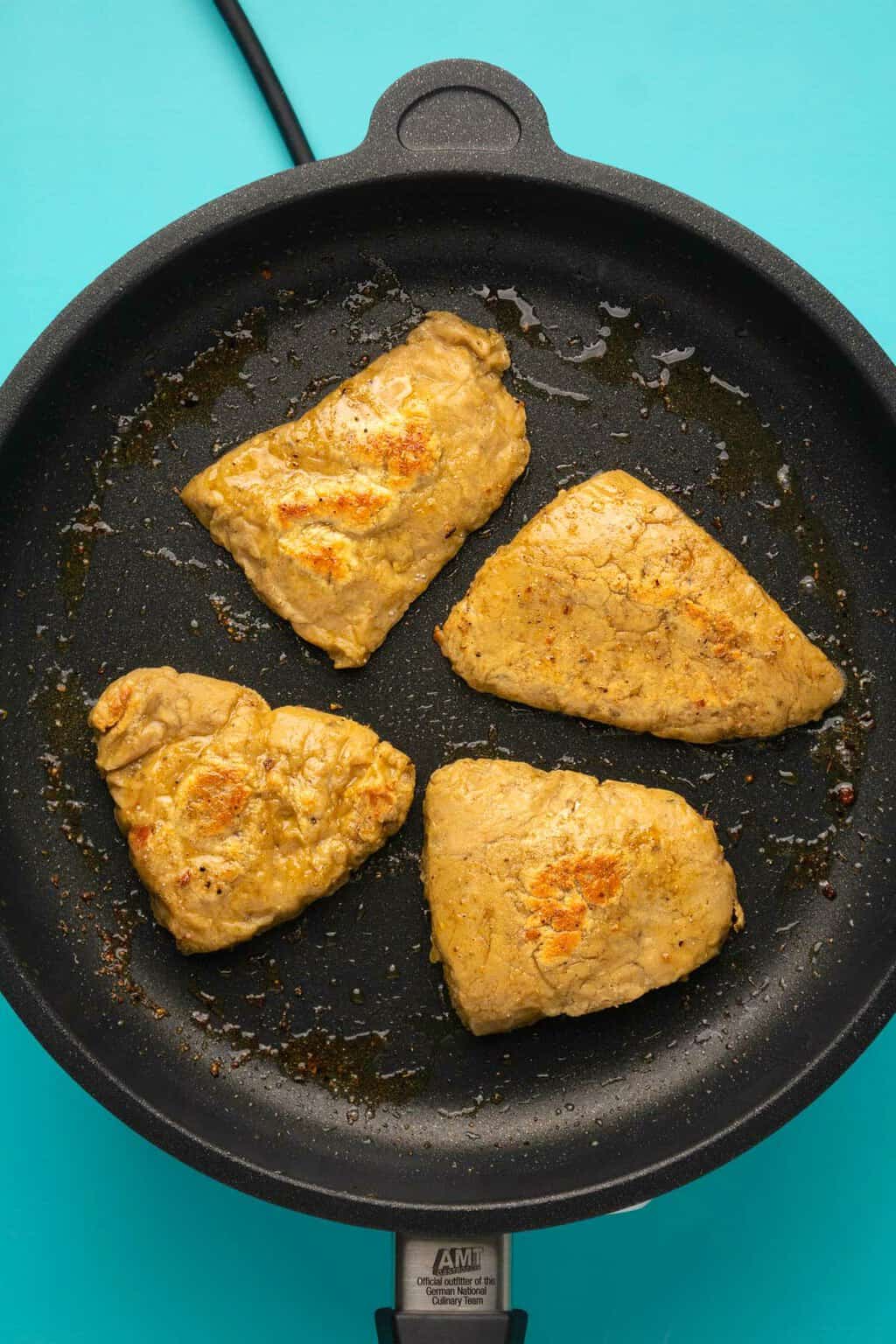 Filets de poulet végétaliens frire dans une poêle.