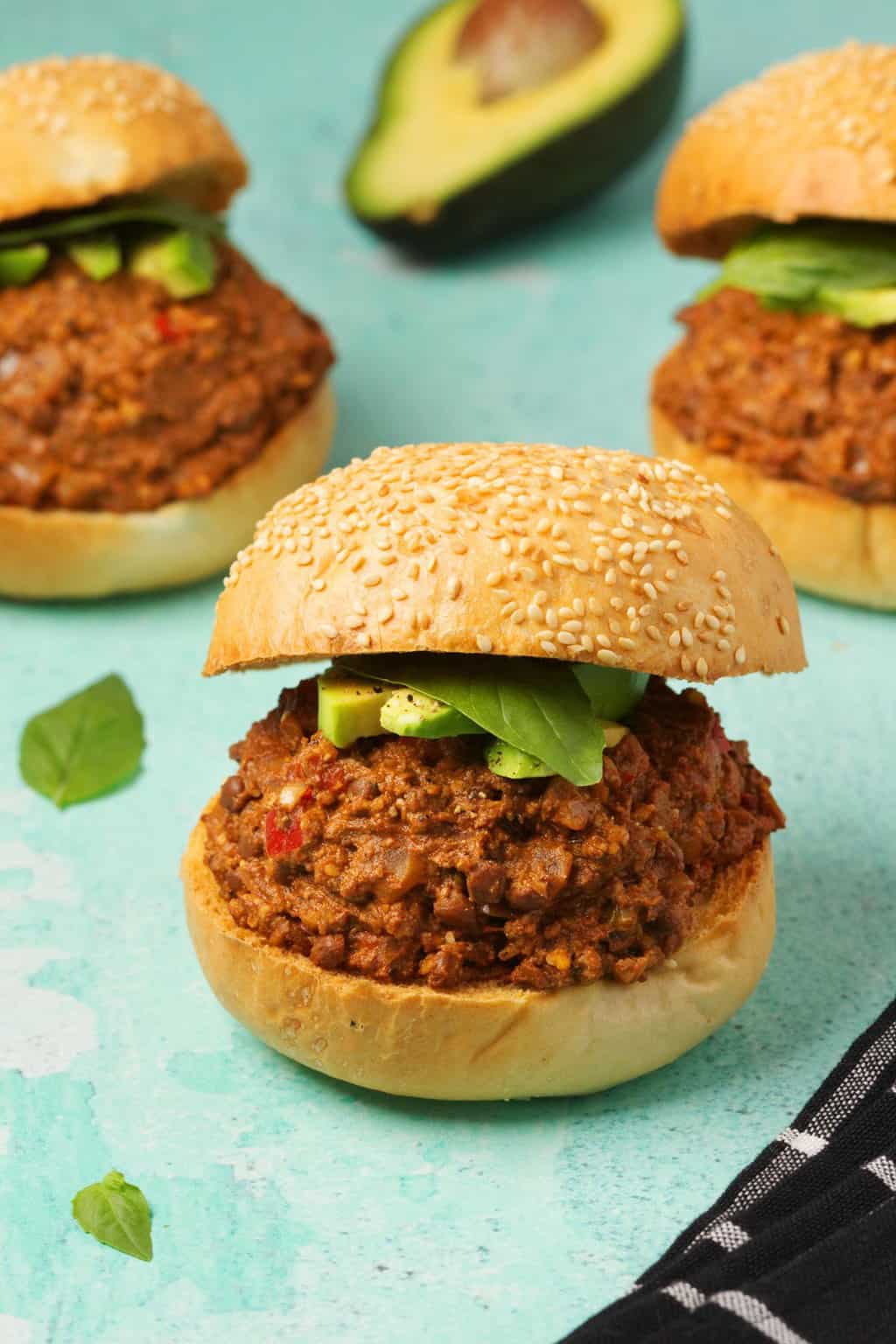 Vegan Sloppy Joes garni d'avocat en tranches et de basilic frais. 