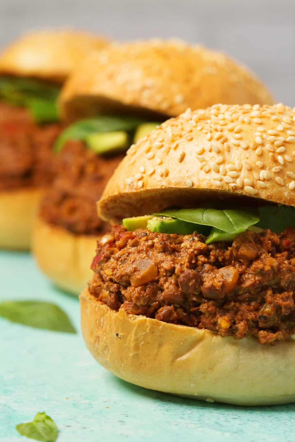 Vegan Sloppy Joes garni d'avocat en tranches et de basilic frais. 