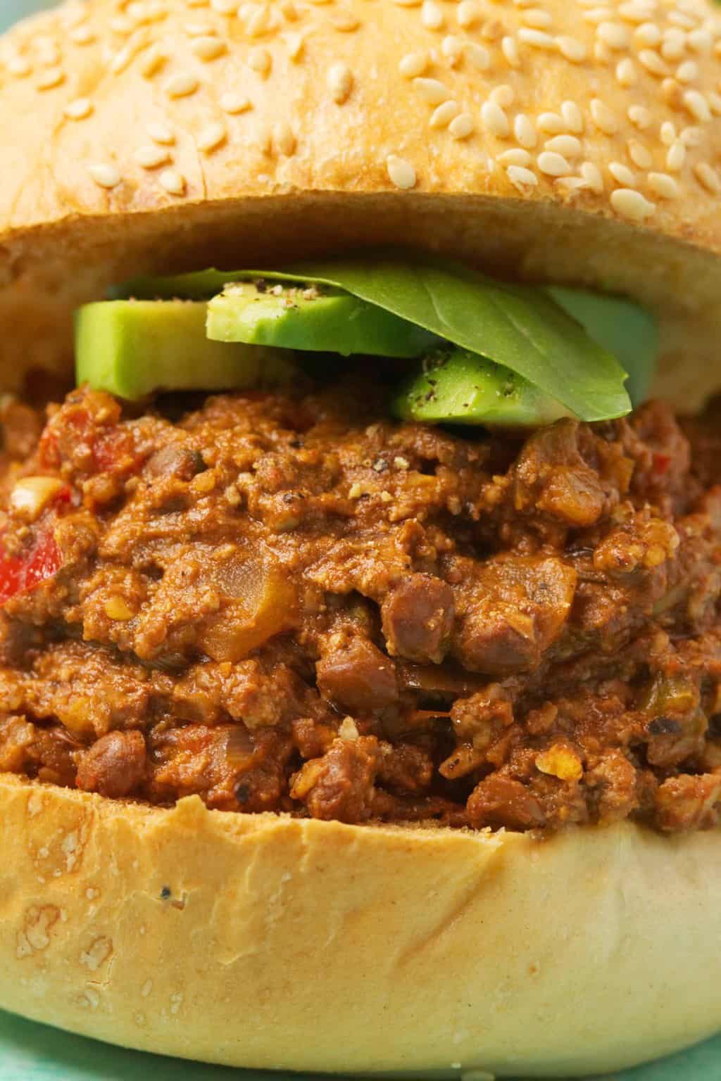 Vegan Sloppy Joe avec des tranches d'avocat et de basilic frais. 