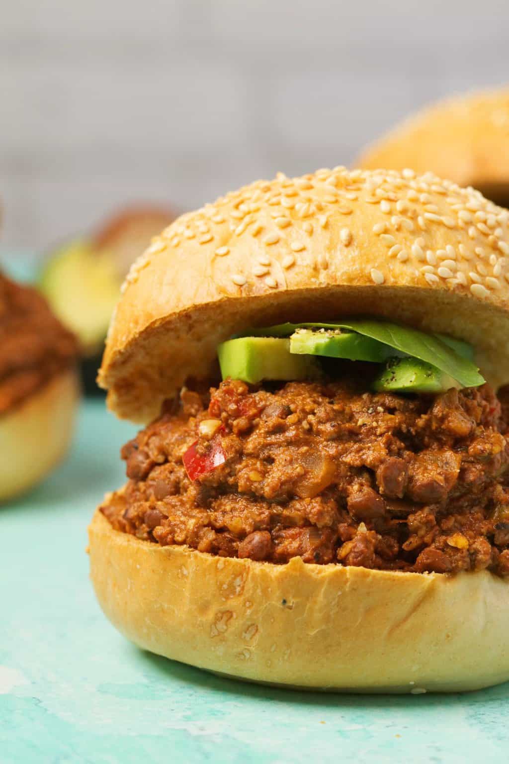 Vegan Sloppy Joe garni d'avocat en tranches et de basilic frais. 