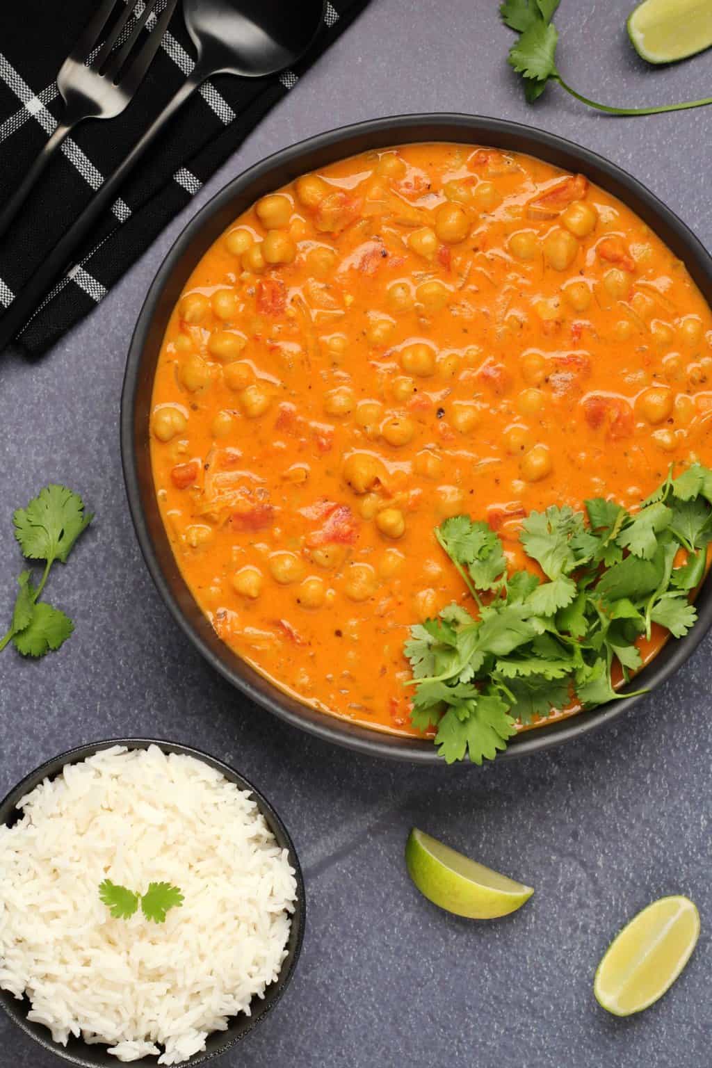 Curry de pois chiches végétalien garni de coriandre fraîche dans un bol noir.