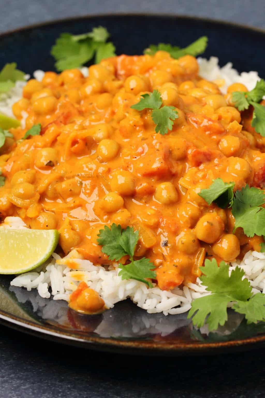 Curry de pois chiches servi sur du riz basmati dans un bol noir.