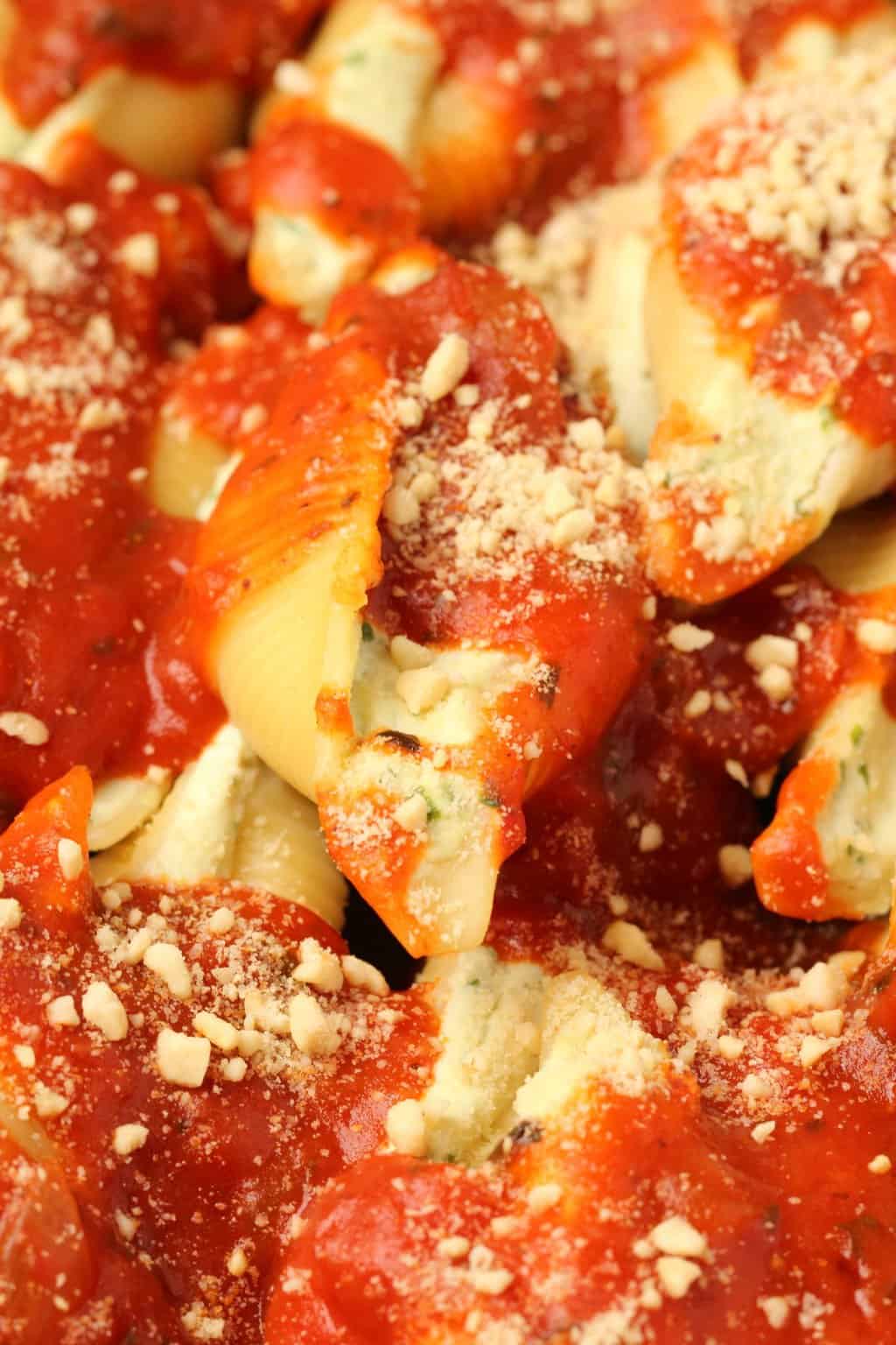 Coquilles farcies végétaliennes garnies de sauce marinara et de parmesan végétalien.