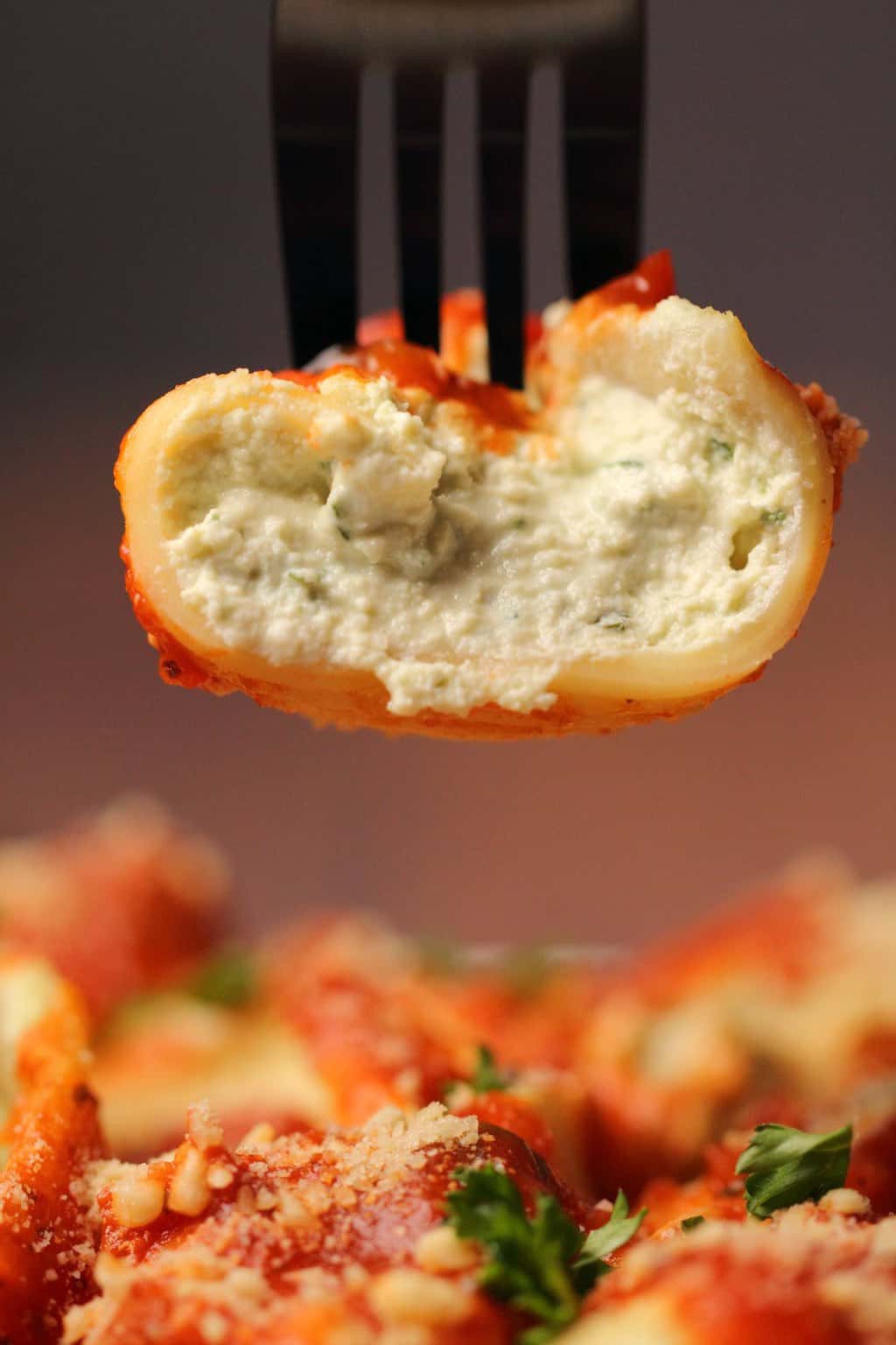 Coquille de pâtes farcies végétaliennes sur une fourchette.