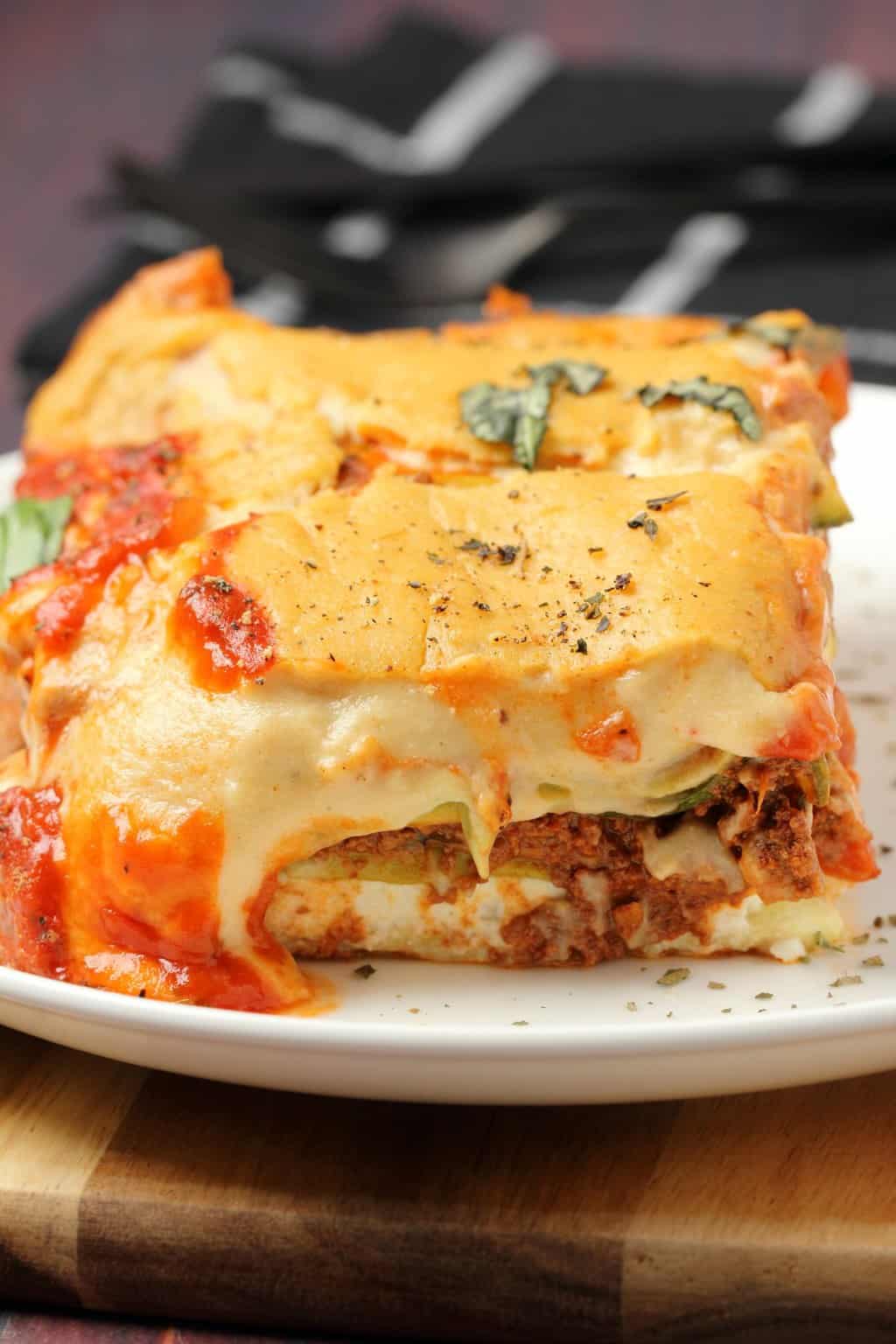 Une tranche de lasagne végétalienne sur une plaque blanche. 