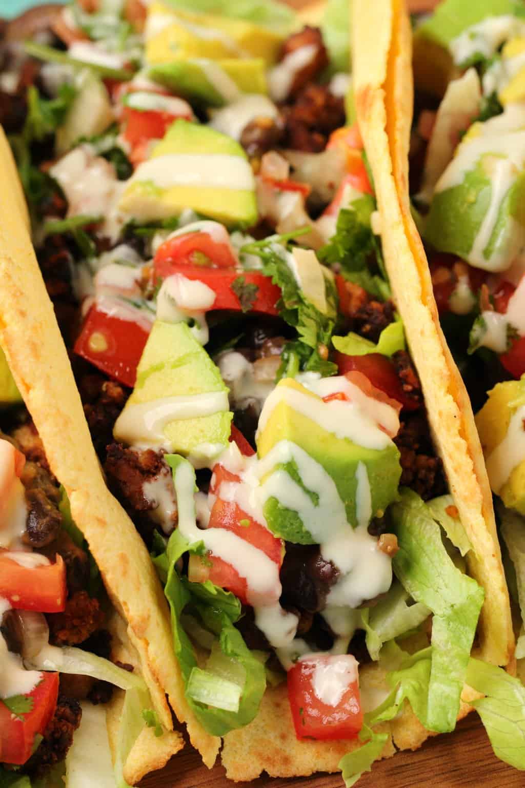 Tacos végétaliens farcis sur une planche de bois. 